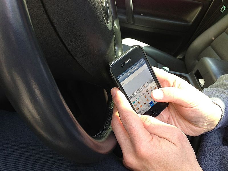 Image of person texting while driving